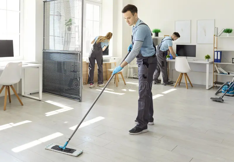 A Force housekeeping personnel cleaning and mopping office floor